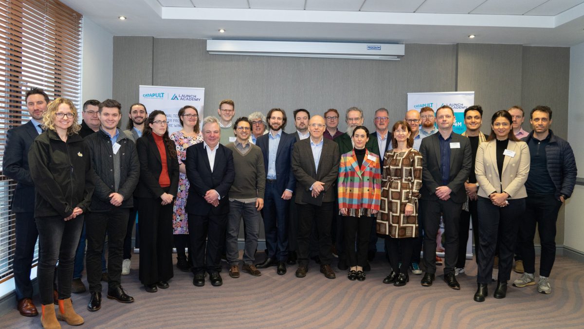 Group photograph of 30-40 people in an indoor setting facing the camera
