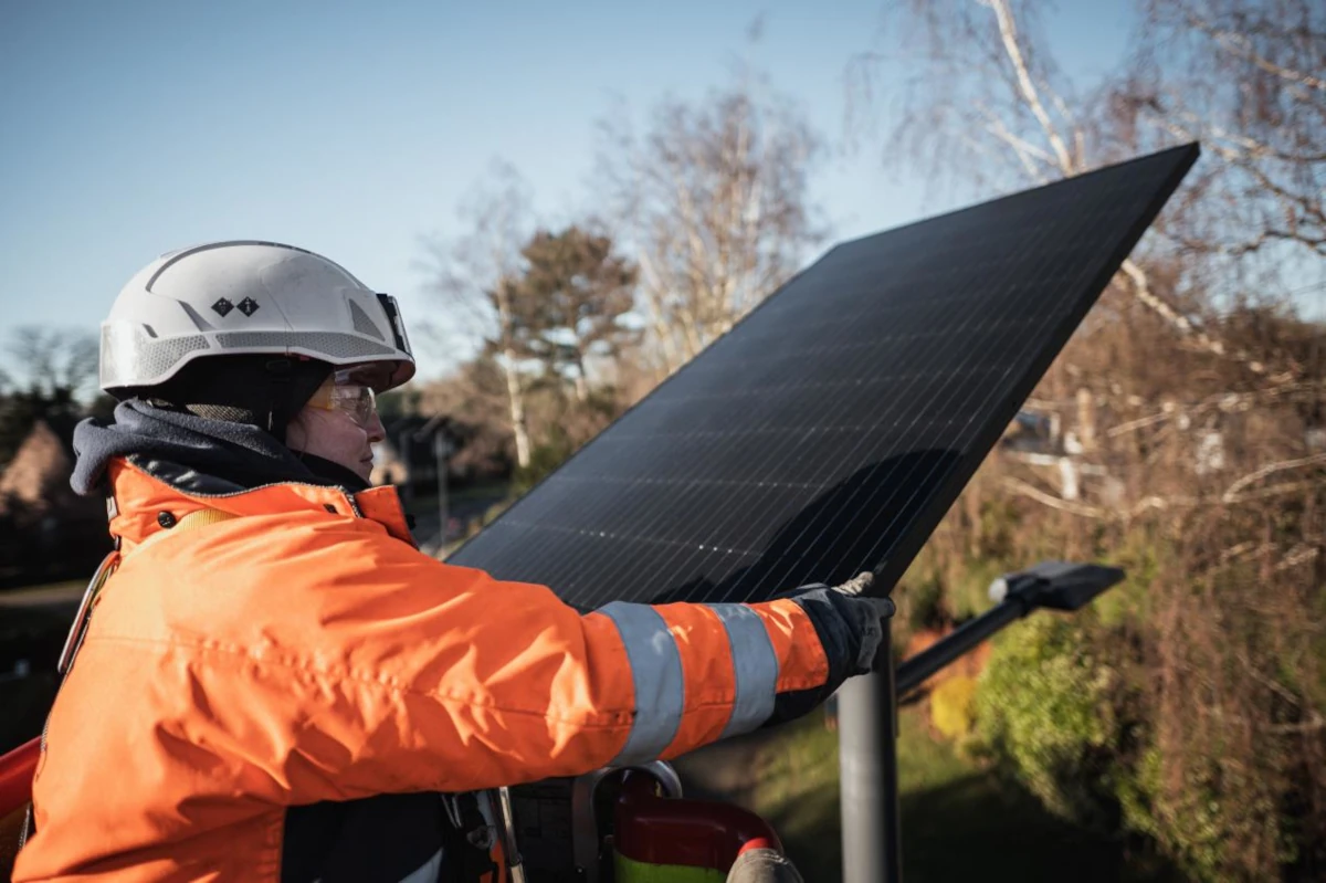 Construction worker fiddling with a solar panel